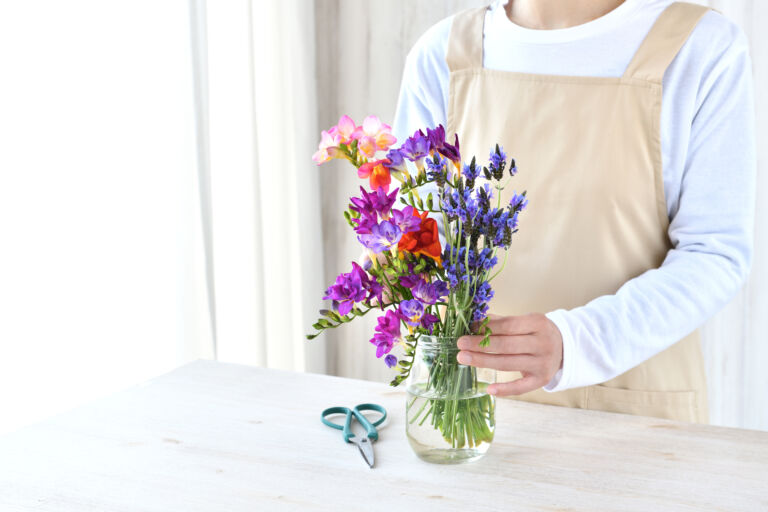 Woman arranging flowers in living room